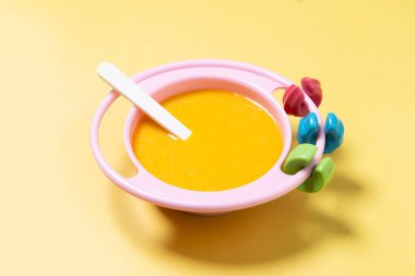 Bebek mamasıyla bovling. Sarı arka planda sebze püresi