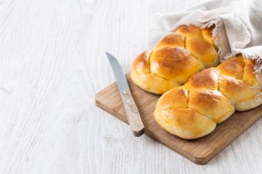 Geleneksel Paskalya örülmüş ekmek. Tahta masada Tsoureki örgüsü