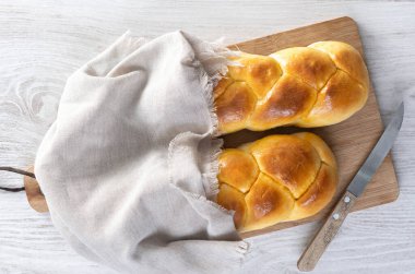 Geleneksel Paskalya örülmüş ekmek. Tahta masada Tsoureki örgüsü