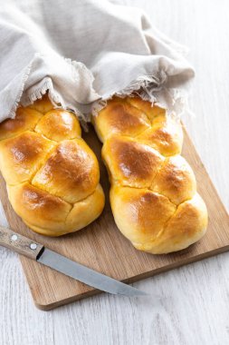 Geleneksel Paskalya örülmüş ekmek. Tahta masada Tsoureki örgüsü