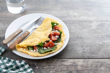 Domatesli omlet ve ahşap masada ıspanak. Boşluğu kopyala