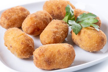Kızarmış morina kroketleri beyaz arkaplanda izole edilmiş.
