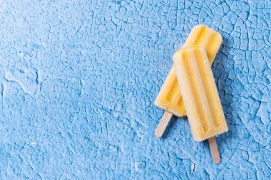 Mavi arka planda sarı buzlu şeker. Üst Manzara. Boşluğu kopyala