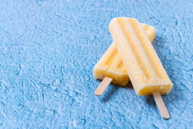 Mavi arka planda sarı buzlu şeker. Boşluğu kopyala