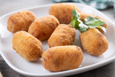 Tahta masada kızarmış morina kroketleri. Kapat.