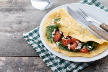 Domatesli omlet ve ahşap masada ıspanak. Boşluğu kopyala