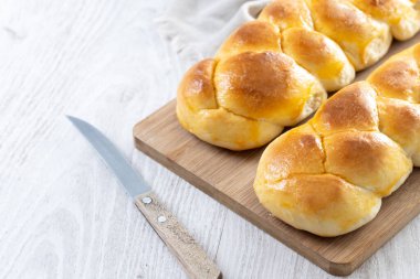 Geleneksel Paskalya örülmüş ekmek. Tahta masada Tsoureki örgüsü