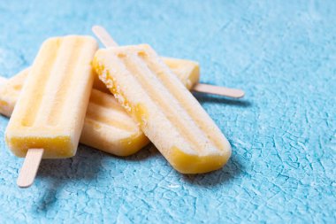 Mavi arka planda sarı buzlu şeker. Boşluğu kopyala