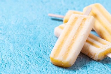 Mavi arka planda sarı buzlu şeker. Boşluğu kopyala