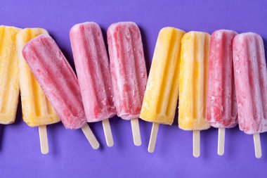 Mor arkaplanda sarı ve kırmızı buzlu şeker