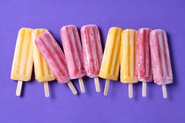 Mor arkaplanda sarı ve kırmızı buzlu şeker