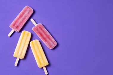 Mor arkaplanda sarı ve kırmızı buzlu şeker