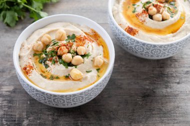 Zeytin yağlı nohut, maydanoz ve ahşap masada kırmızı biber.