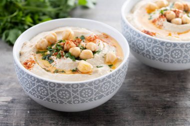 Zeytin yağlı nohut, maydanoz ve ahşap masada kırmızı biber.