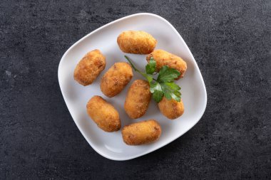 Siyah arkaplanda kızarmış morina kroketleri