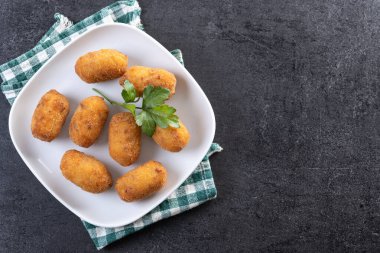 Siyah arkaplanda kızarmış morina kroketleri