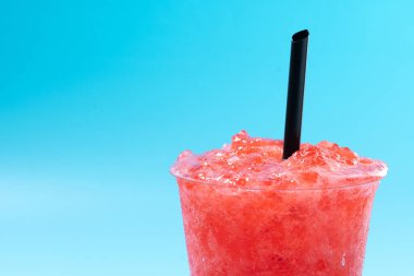 Kırmızı çilekli buzlu içecek mavi arka planda izole edilmiş. Soğuk yaz içkisi. Boşluğu kopyala