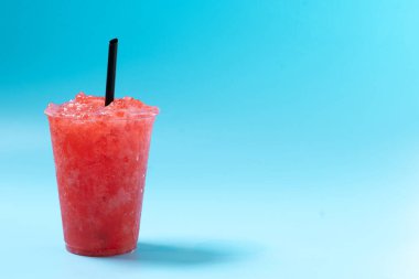 Kırmızı çilekli buzlu içecek mavi arka planda izole edilmiş. Soğuk yaz içkisi. Boşluğu kopyala