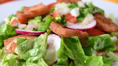Şişko salatasına zeytin yağı dök, geleneksel Lübnan salatası ahşap masaya.