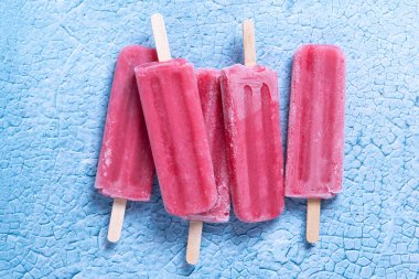 Mavi arka planda çilekli dondurma.