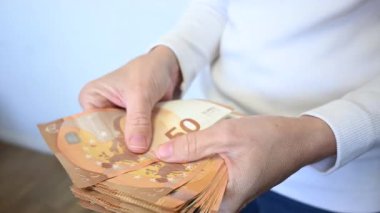 Kadın euro banknotlarını sayıyor. Kapat.