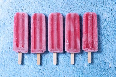 Mavi arka planda çilekli dondurma.