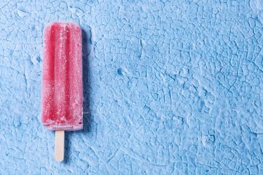 Mavi arka planda çilekli dondurma.