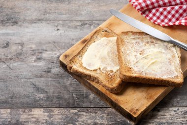 Tahta masada taze ekmek ve tereyağı dilimlenmiş. Boşluğu kopyala