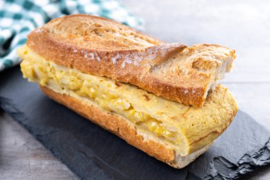 Tahta masada İspanyol patatesli omlet sandviçi. Bocadillo de tortilla