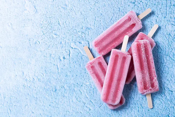 Mavi arka planda kırmızı çilekli dondurma. Üst Manzara. Boşluğu kopyala