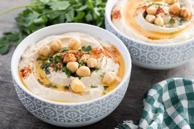 Zeytin yağlı nohut, maydanoz ve ahşap masada kırmızı biber.