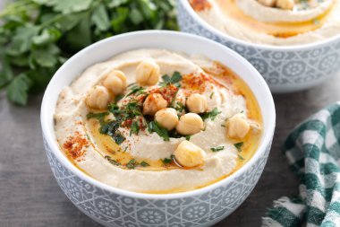 Zeytin yağlı nohut, maydanoz ve ahşap masada kırmızı biber.