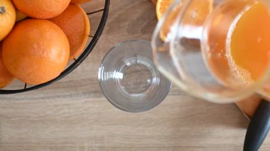 Bir bardağa portakal suyu döküyorum. Üst görünüm