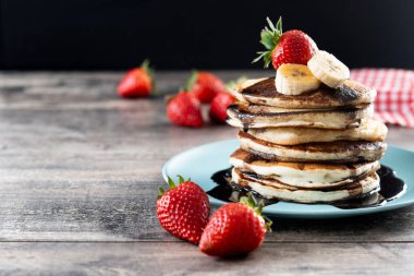 Tahta masada çikolatalı ve meyveli krep. Boşluğu kopyala