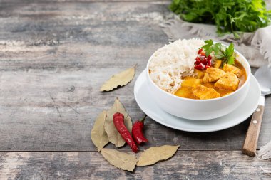 Massaman körisi ahşap masada kasede. Geleneksel Tayland yemek tarifi. Boşluğu kopyala