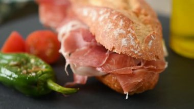 Tahta masada İspanyol jambonlu sandviç. İspanyol Bocadillo de jamon Serrano