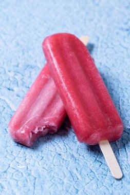 Mavi arka planda kırmızı çilekli dondurma..