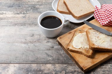 Tahta masada taze ekmek ve tereyağı dilimlenmiş. Boşluğu kopyala