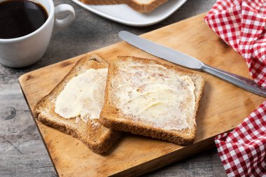 Tahta masada taze ekmek ve tereyağı dilimlenmiş.