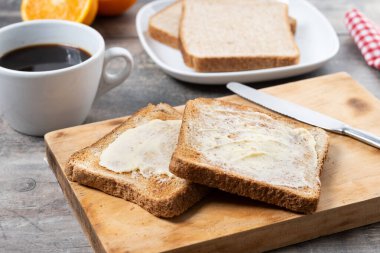 Tahta masada taze ekmek ve tereyağı dilimlenmiş.