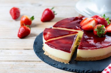 Tahta masada çilekli cheesecake dilimi. Boşluğu kopyala