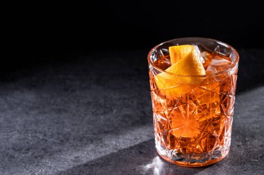 Siyah arka planda turuncu kıvrımlı Americano kokteyli. Boşluğu kopyala