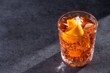 Siyah arka planda turuncu kıvrımlı Americano kokteyli. Boşluğu kopyala