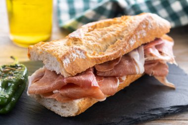 Tahta masada İspanyol jambonlu sandviç. İspanyol Bocadillo de jamon Serrano