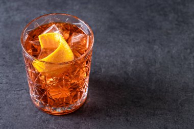 Siyah arka planda turuncu bükülmüş Americano kokteyli. Boşluğu kopyala