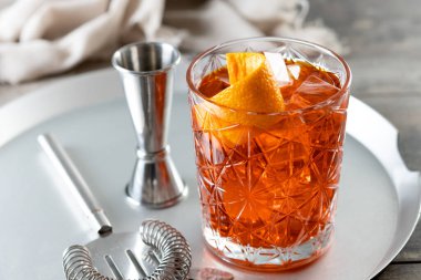 Amerikan kokteyli, ahşap masada turuncuyla süslenmiş.