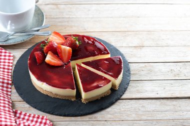 Tahta masada çilekli cheesecake dilimi. Boşluğu kopyala