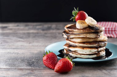 Tahta masada çikolatalı ve meyveli krep. Boşluğu kopyala