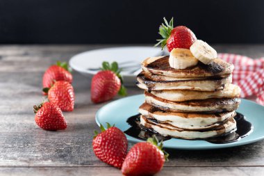 Tahta masada çikolatalı ve meyveli krep. Boşluğu kopyala