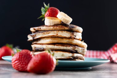 Çikolatalı gözleme ve ahşap masada meyve.